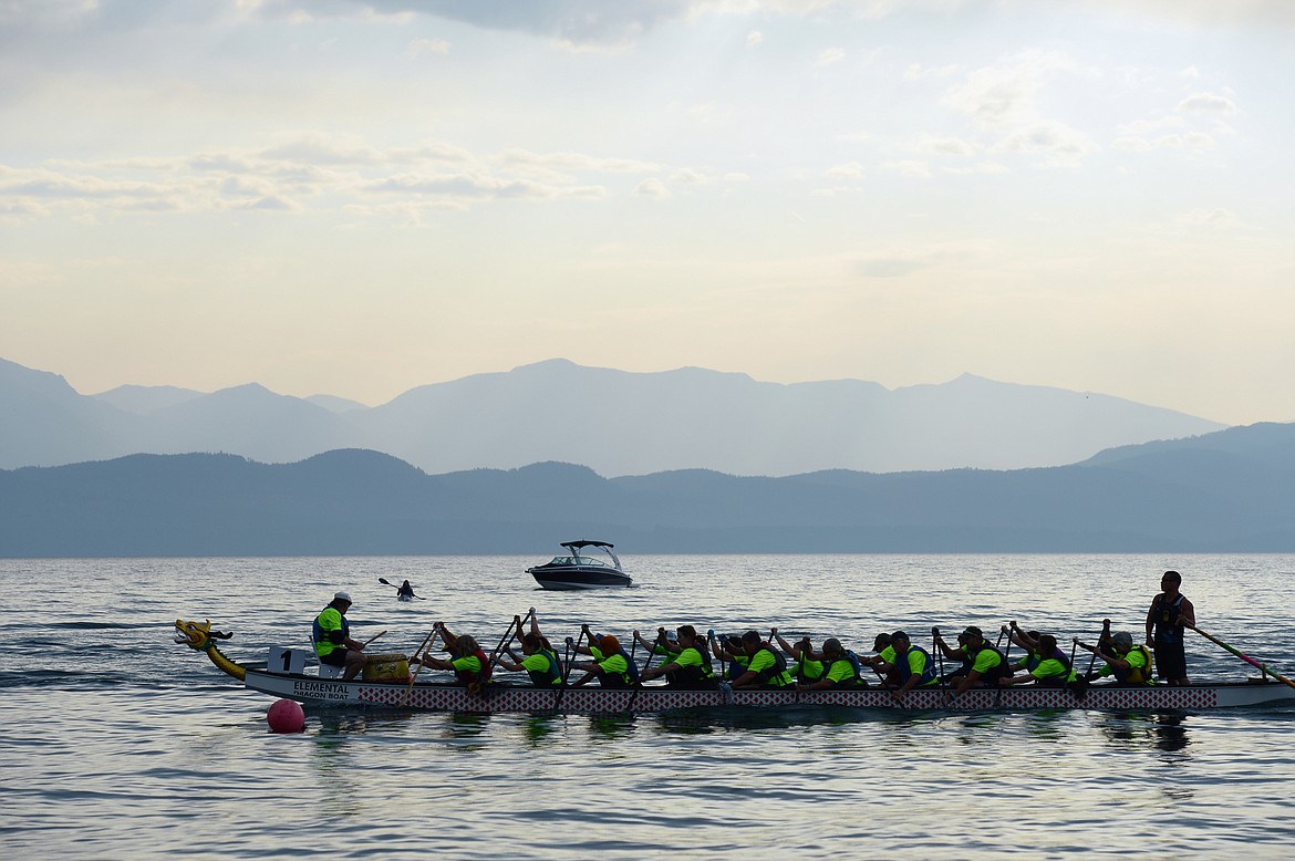 The Buzz, from Helena, paddle across the finish line during the Dragon Boat Festival at Volunteer Park in Lakeside on Saturday. (Casey Kreider/Daily Inter Lake)