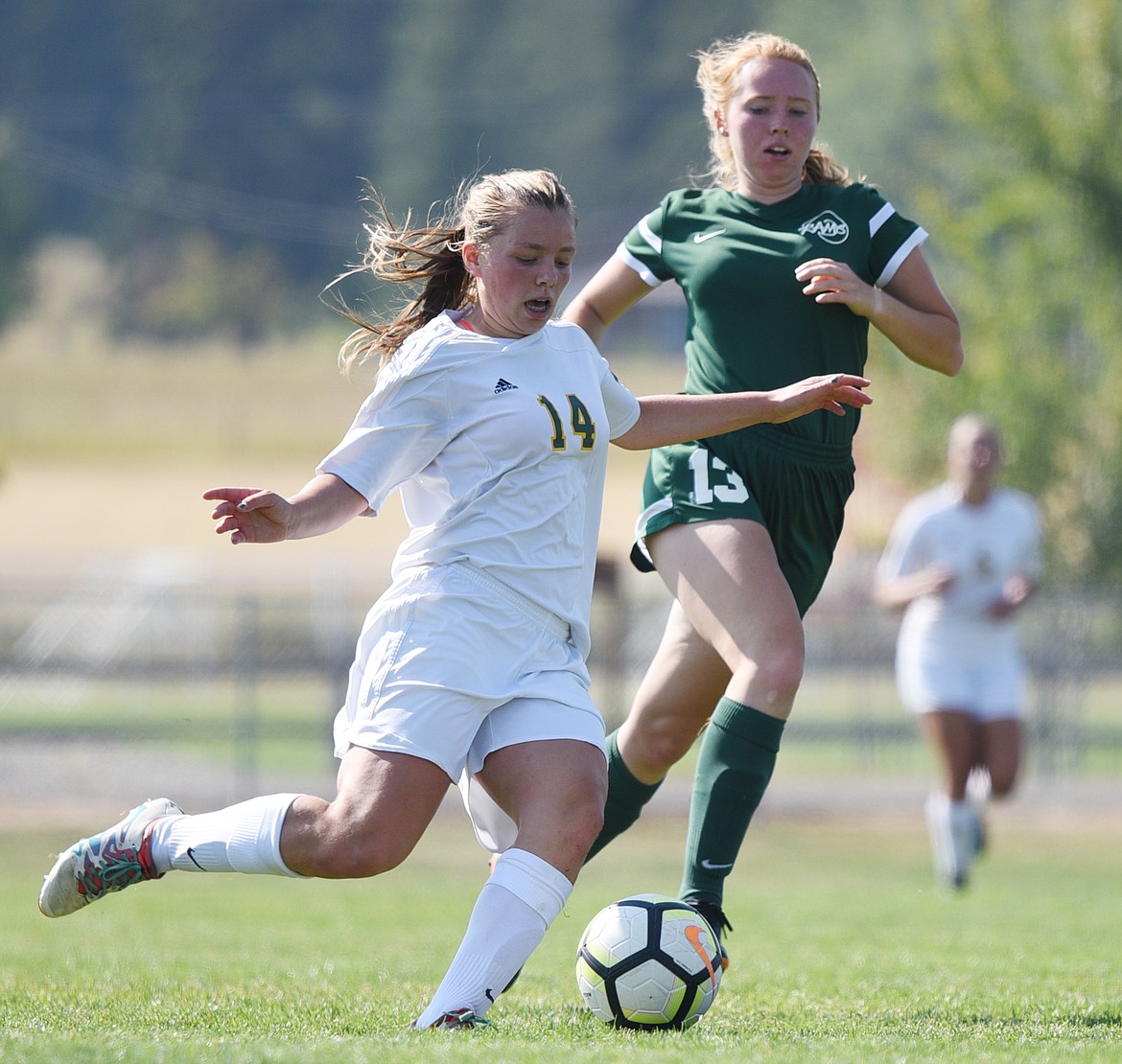 Whitefish's Josie Schneider (14) looks to pass with Billings Central's Annika Varga (13) defending at Smith Fields in Whitefish on Saturday. (Casey Kreider/Daily Inter Lake)