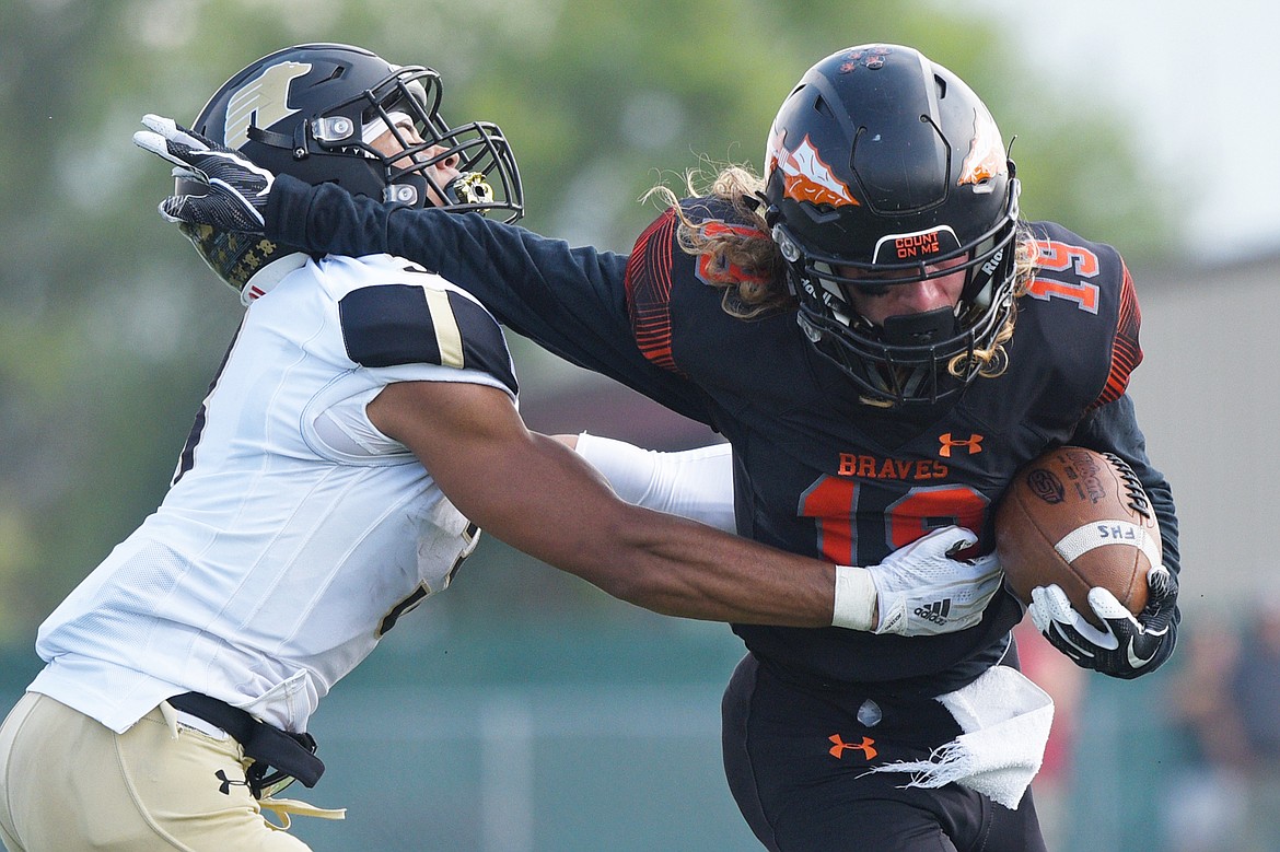 Flathead wide receiver Kaden Wills (19) tries to break a tackle by Billings West's Jesse Owen (3) at Legends Stadium on Friday. (Casey Kreider/Daily Inter Lake)