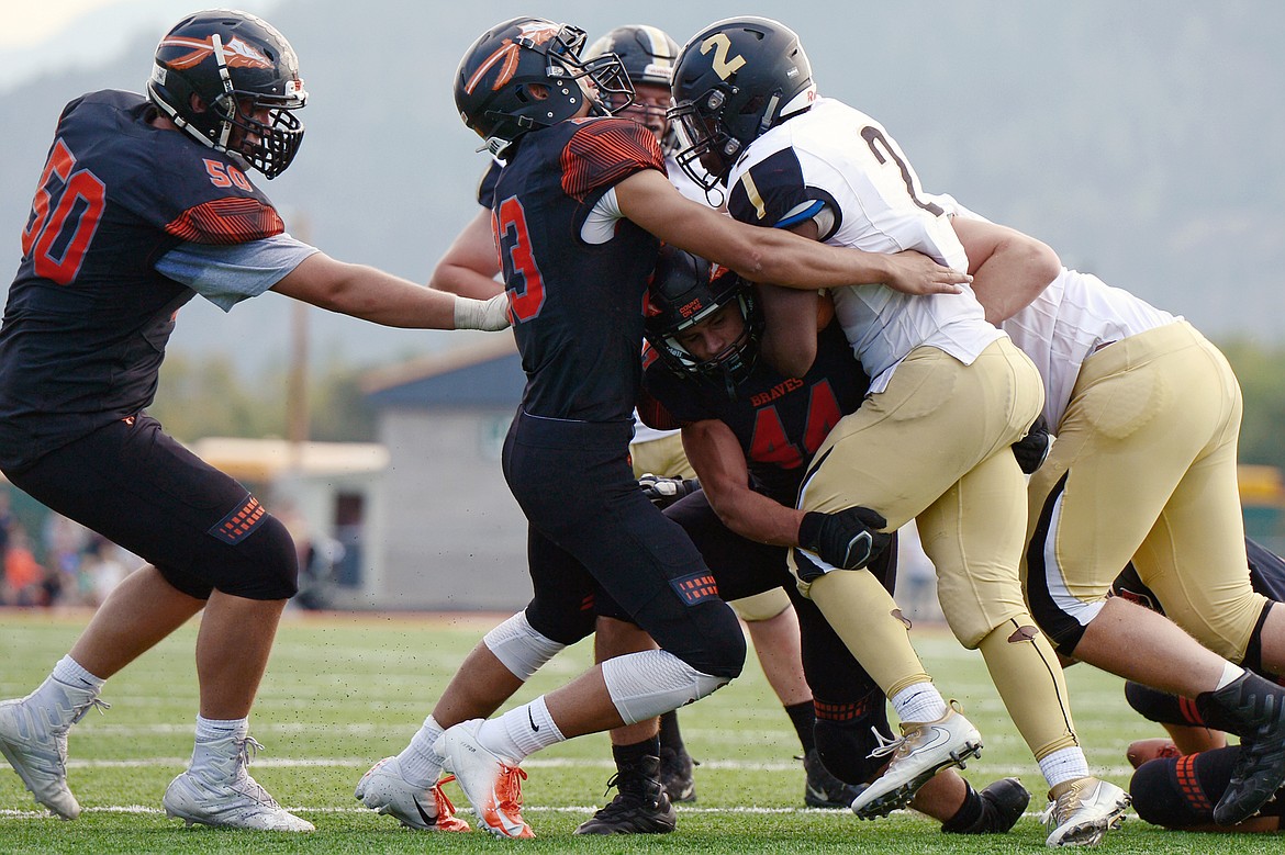 Billings West running back Demarcus Carr (2) is stacked up by Flathead defenders Gannon Welder (23) and Tanner Russell (44) at Legends Stadium on Friday. (Casey Kreider/Daily Inter Lake)