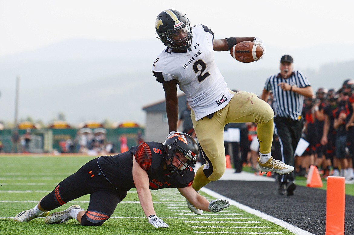 Billings West running back Demarcus Carr breaks a tackle by Flathead's Tannon Beyl (5) on a long run at Legends Stadium on Friday. (Casey Kreider/Daily Inter Lake)