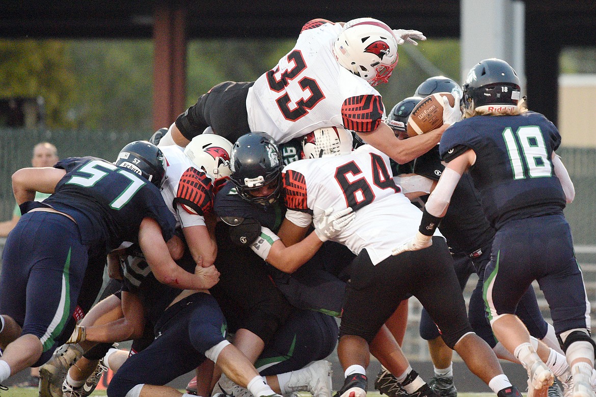 Bozeman running back Joe Olson leaps over the pile for a 3-yard touchdown run in the second quarter against Glacier at Legends Stadium on Friday. (Casey Kreider/Daily Inter Lake)