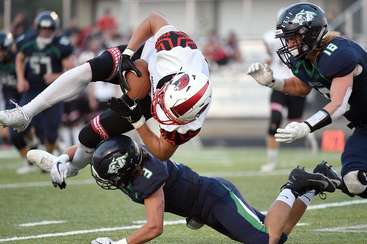 Glacier's Danny Anderson (3) and Garret Frost (18) upend Bozeman tight end Ryan Lonergan on a first quarter reception at Legends Stadium on Friday. (Casey Kreider/Daily Inter Lake)