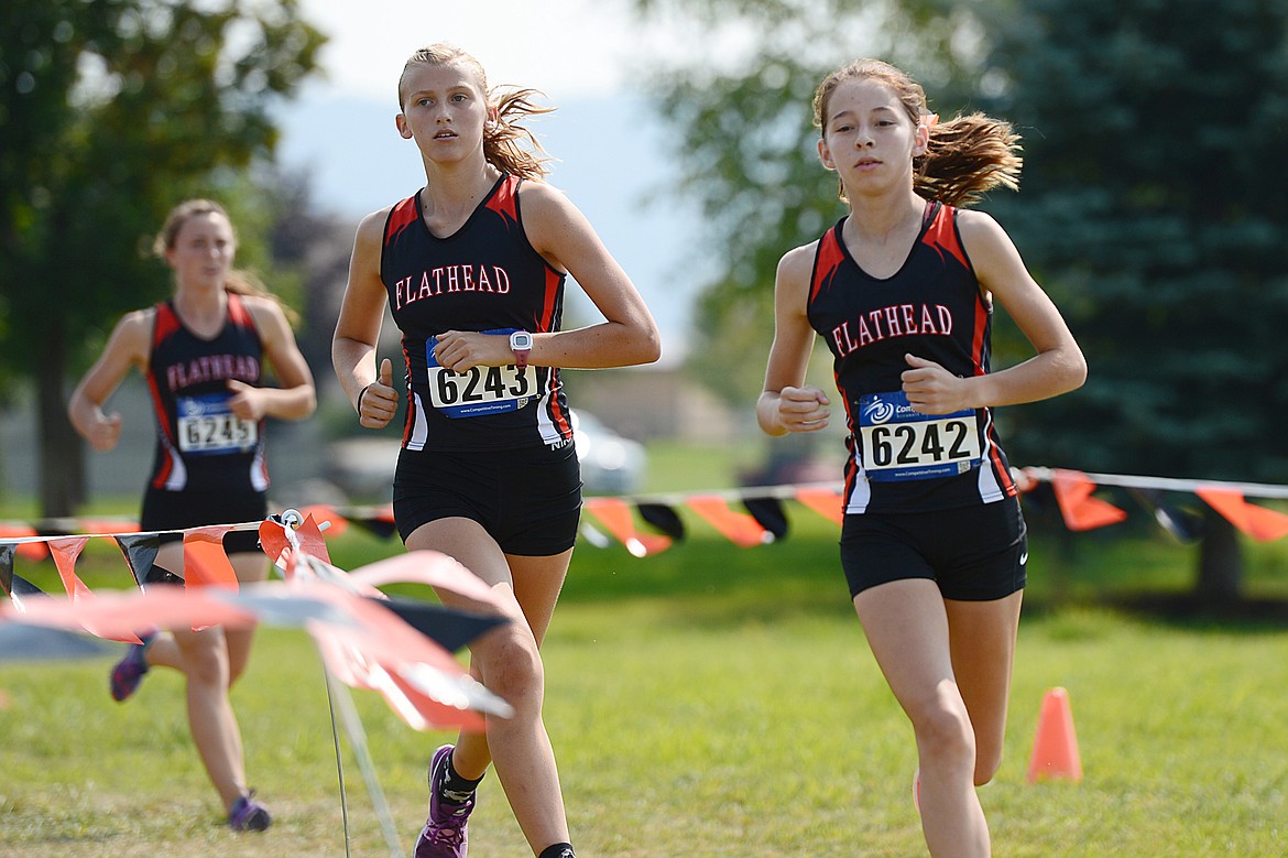 From left, Flathead's Sadie Wilson, Hannah Perrin and Tori Noland-Gillespie round a bend at the Flathead Invite at Rebecca Farm on Friday. (Casey Kreider/Daily Inter Lake)