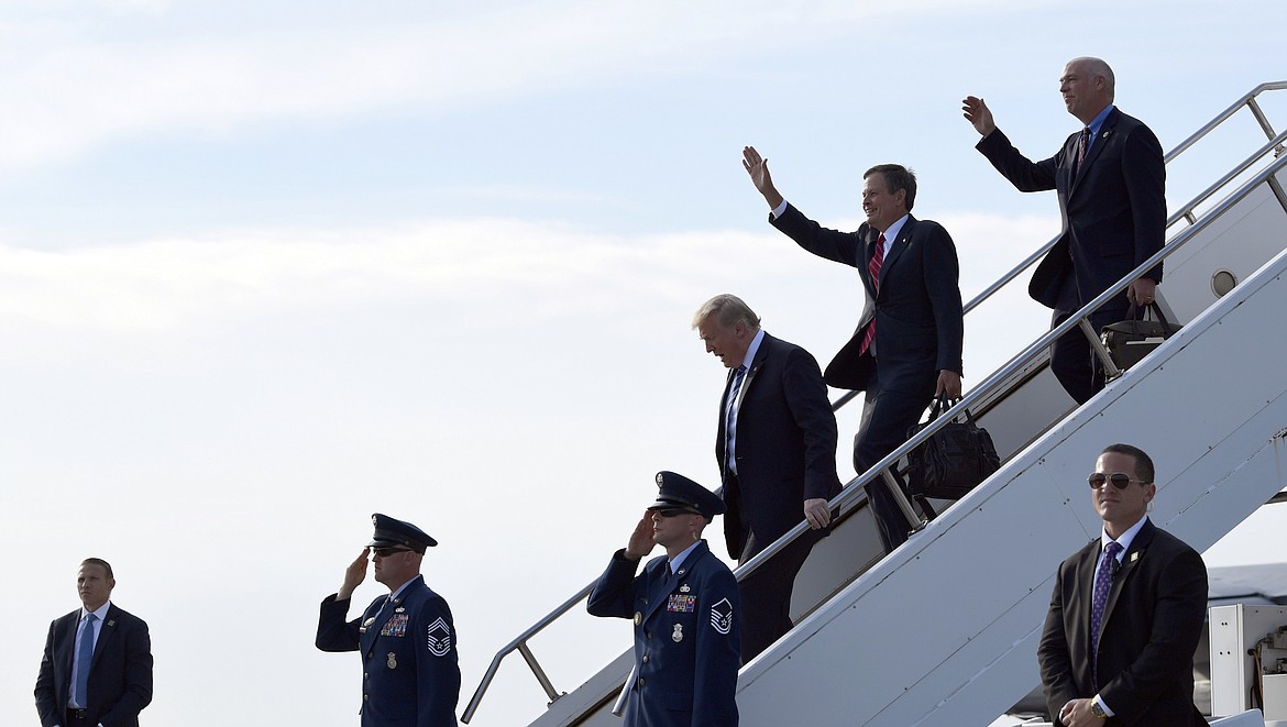 President Donald Trump, third from right, walks off of Air Force One at Billings Logan International Airport in Billings, Mont., Thursday, Sept. 6, 2018, with Sen. Steve Daines, R-Mont., second from right, and Rep Greg Gianforte, R-Mont. Trump is in Montana for a rally. (AP Photo/Susan Walsh)