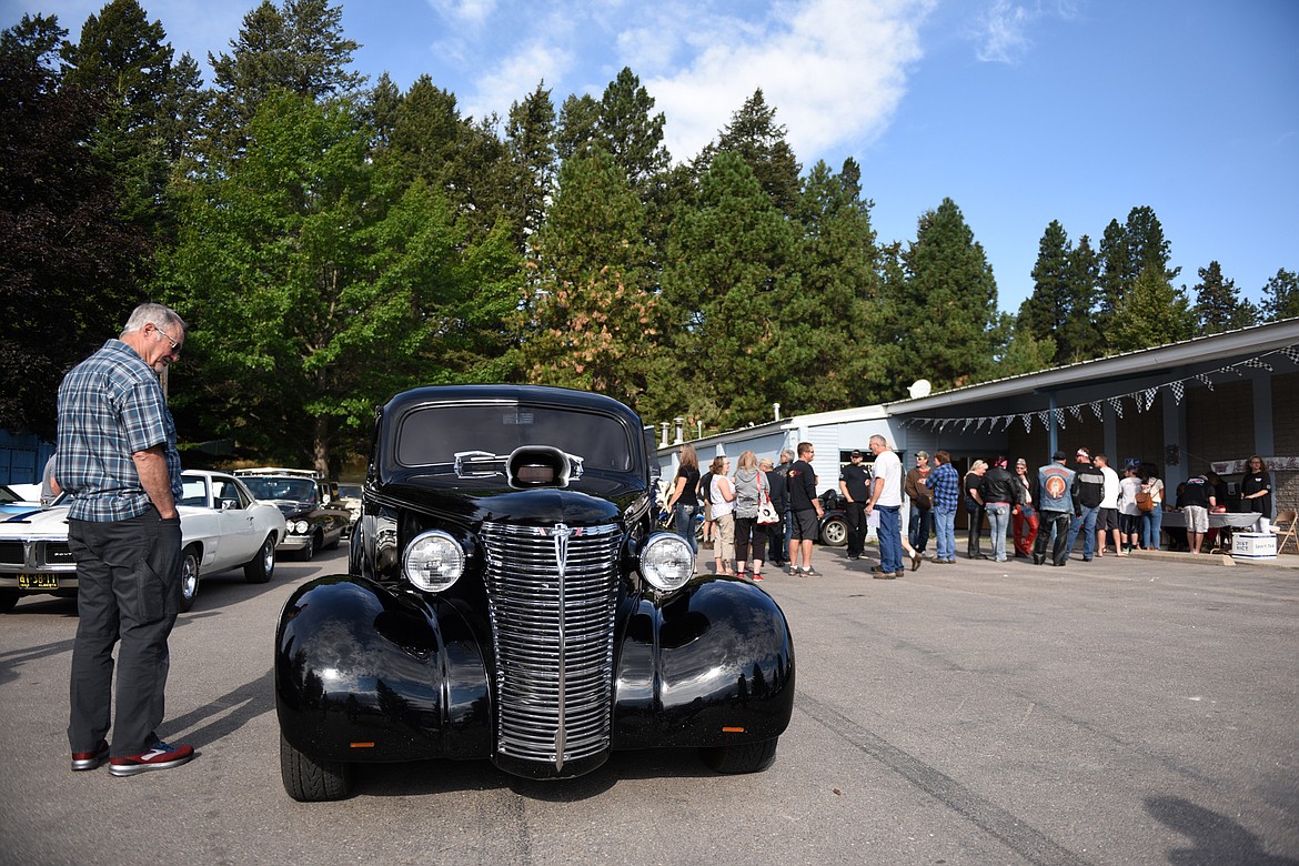 Classic car owners register for the poker run around Flathead Lake outside VFW Post 4042 in Bigfork for the 11th annual Rumble in the Bay car, truck and motorcycle show on Saturday morning. (Casey Kreider/Daily Inter Lake)