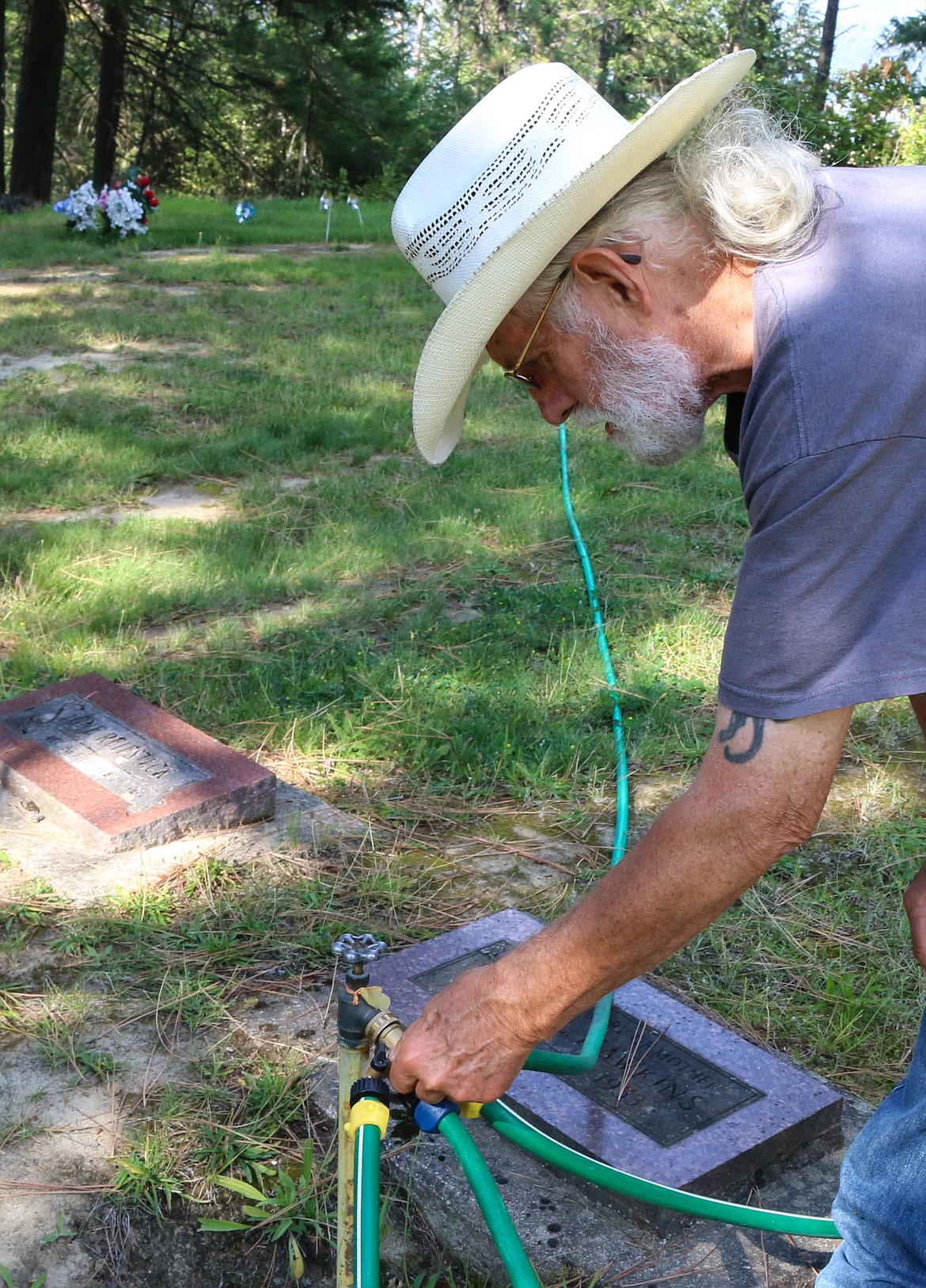 Photo by MANDI BATEMAN
Jim Thompson watering the grass. He has to the clean out the filters constatly due to rust deposits.