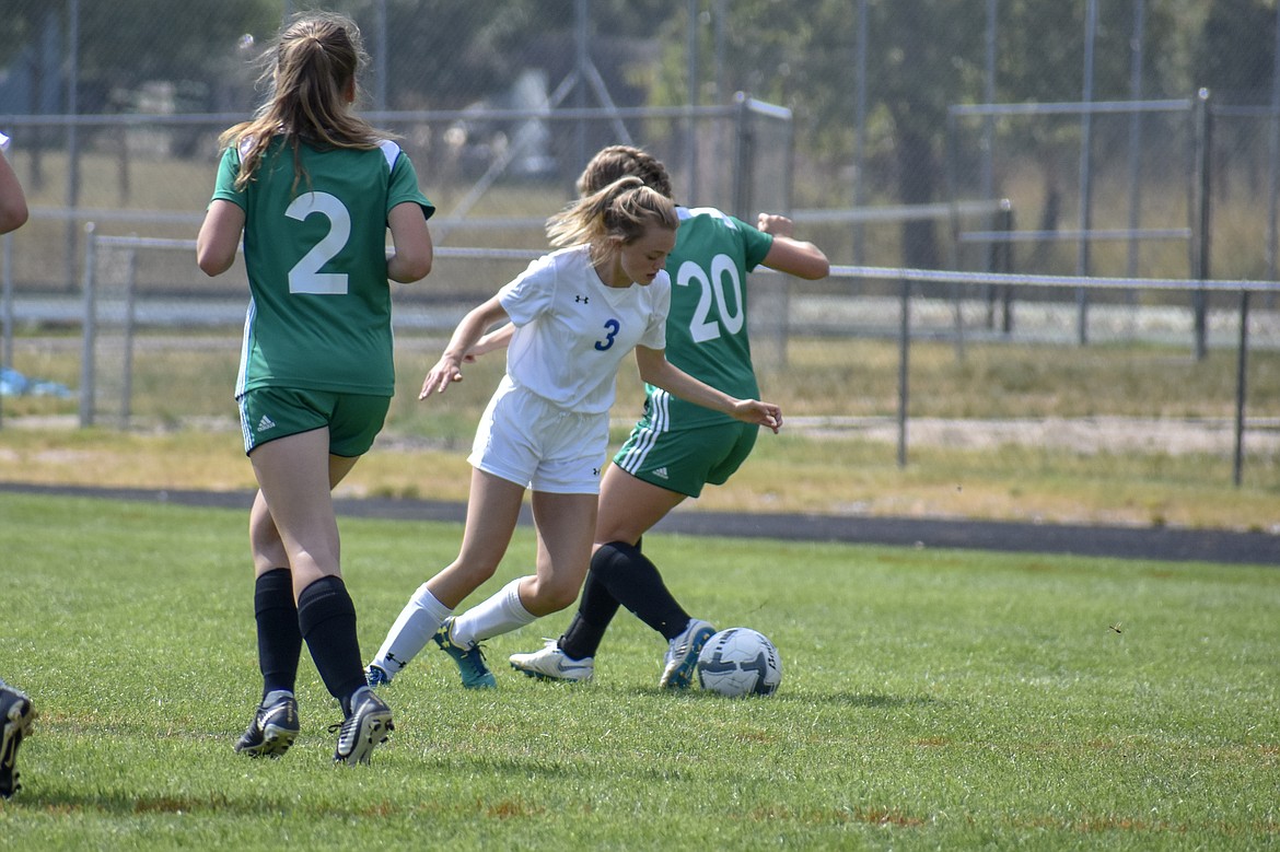Libby junior Lauren Thorstenson slips the ball away from a Belgrade player in the final minutes of the first half of the 9-1 loss to Belgrade Saturday. (Ben Kibbey/The Western News)
