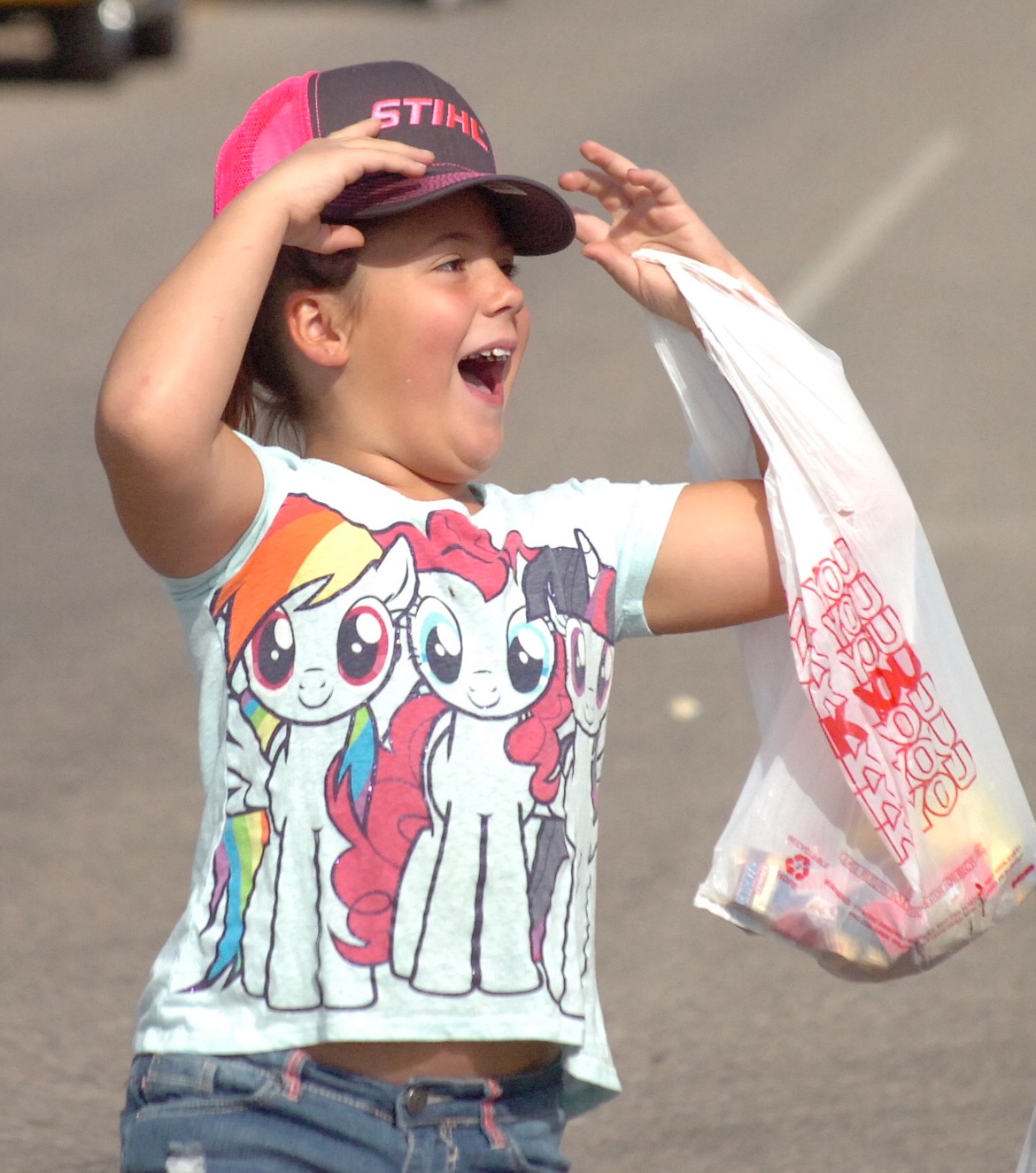 Makayla McNair is really excited after being given a pink cap during the Sanders County Fair Parade. Her mom Casey McNair said, &quot;She really wanted a pink hat, and she got the color she wanted.&quot; (Joe Sova/Clark Fork Valley Press)