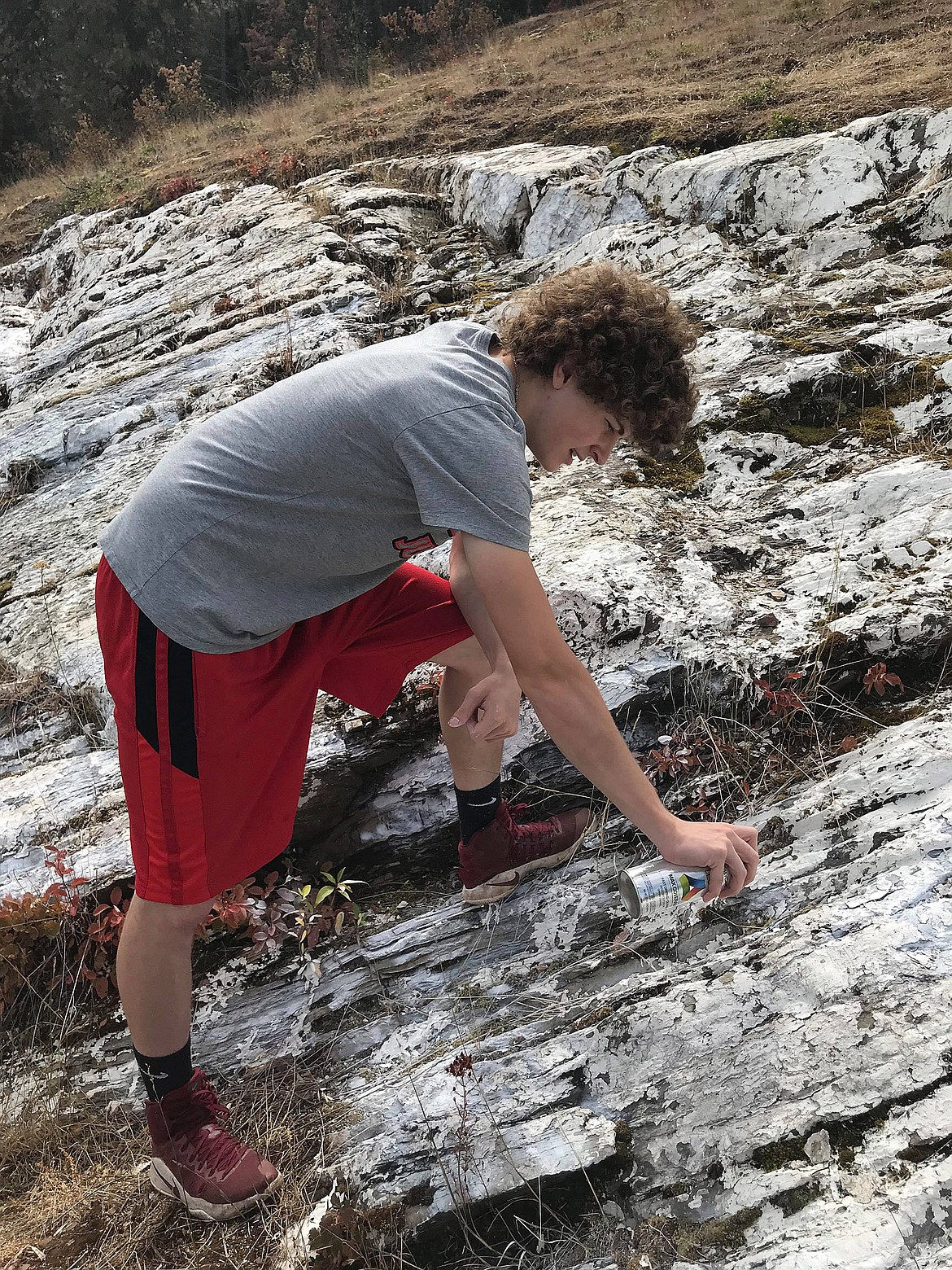 Troy High senior Hunter Leighty paints the Troy &#147;T&#148; Aug. 27. It was one of his ideas to promote leadership and pride during senior year, said his mother Courtney Leighty. &#147;I just wanted a little more Trojan spirit in Troy,&#148; said Hunter. His mother said that Kootenai Drug True Value donated 10 cans of spray paint and three gallons of paint to his project. (Photos by Jayden Leighty)