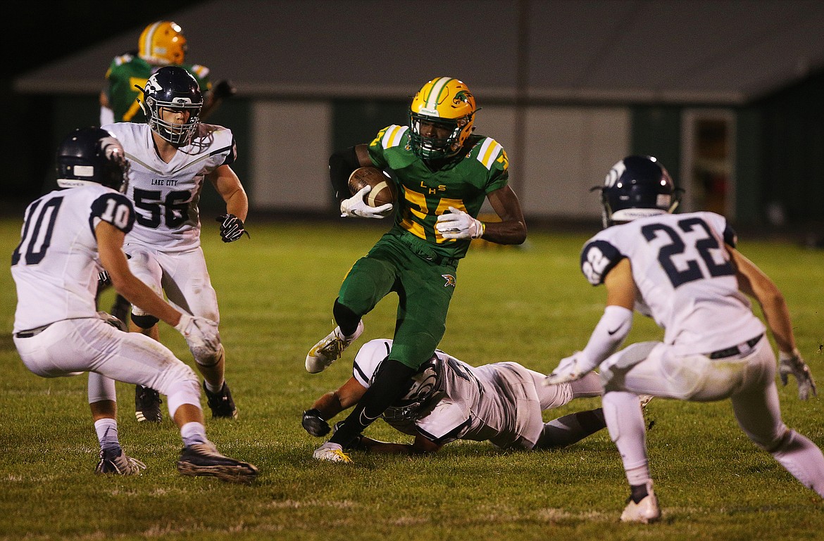 Lakeland High&#146;s Trey McArthur rushes upfield between Lake City defenders during Friday night&#146;s game in Rathdrum.