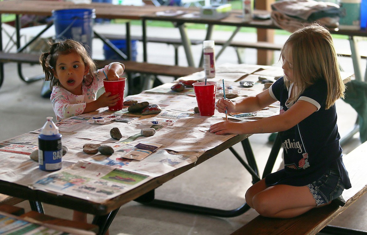 Melody Goodwin and Keeley Schumacher enjoy rock painting at the Civic Action Festival in City Park on Saturday afternoon. (JUDD WILSON/Press)
