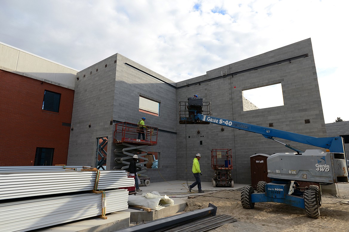 Workers outside what will become the new gymnasium along 5th Avenue West at Flathead High School on Wednesday. (Casey Kreider/Daily Inter Lake)