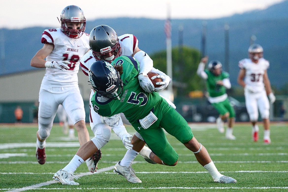 Glacier wide receiver Drew Deck (5) hangs on to a long reception from quarterback Evan Todd (2) in the first quarter against Helena at Legends Stadium on Friday. (Casey Kreider/Daily Inter Lake)