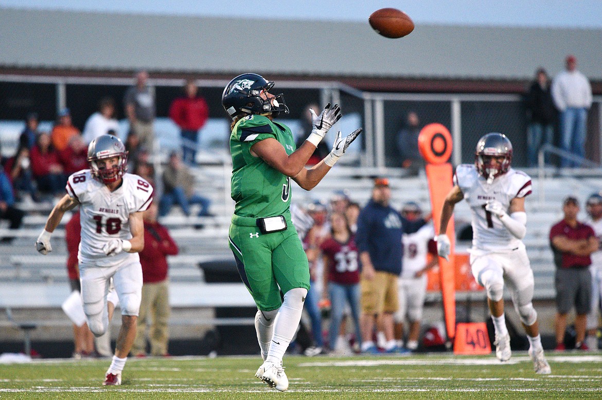 Glacier wide receiver Danny Anderson (3) hauls in a long touchdown reception in the second quarter in front of Helena defenders Cooper Biegler (18) and Connor Murgel (1) at Legends Stadium on Friday. (Casey Kreider/Daily Inter Lake)