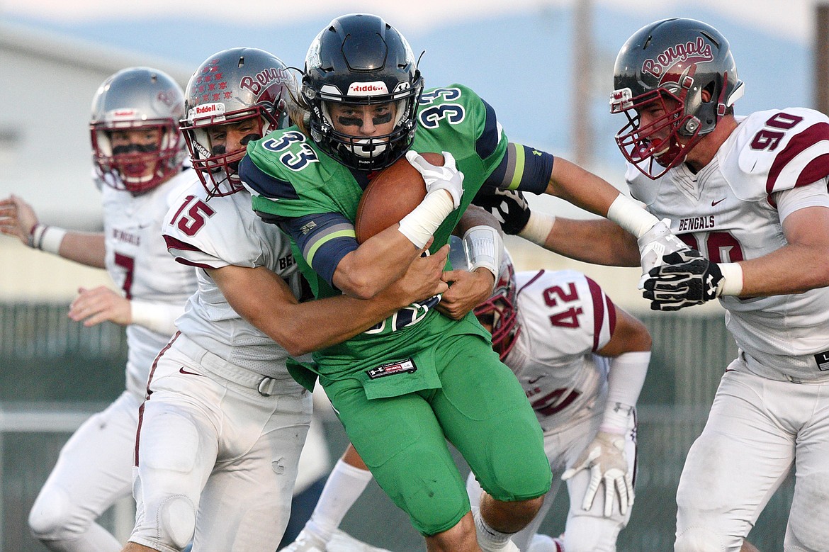 Glacier running back Preston Blain (33) is wrapped up by Helena&#146;s Hayden Ferguson (15) on a second quarter run at Legends Stadium on Friday. (Casey Kreider/Daily Inter Lake)