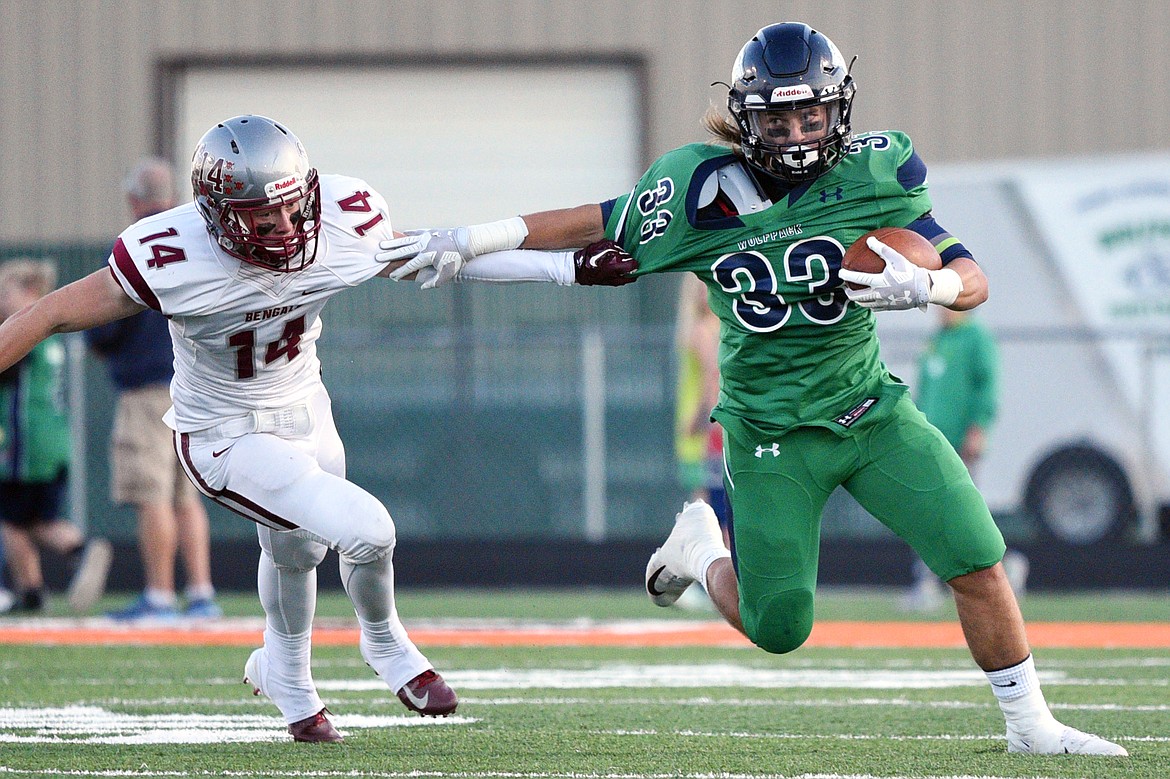 Glacier running back Preston Blain tries to turn the corner past Helena defender Zachary Spiroff (14) on a second quarter run at Legends Stadium on Friday. (Casey Kreider/Daily Inter Lake)