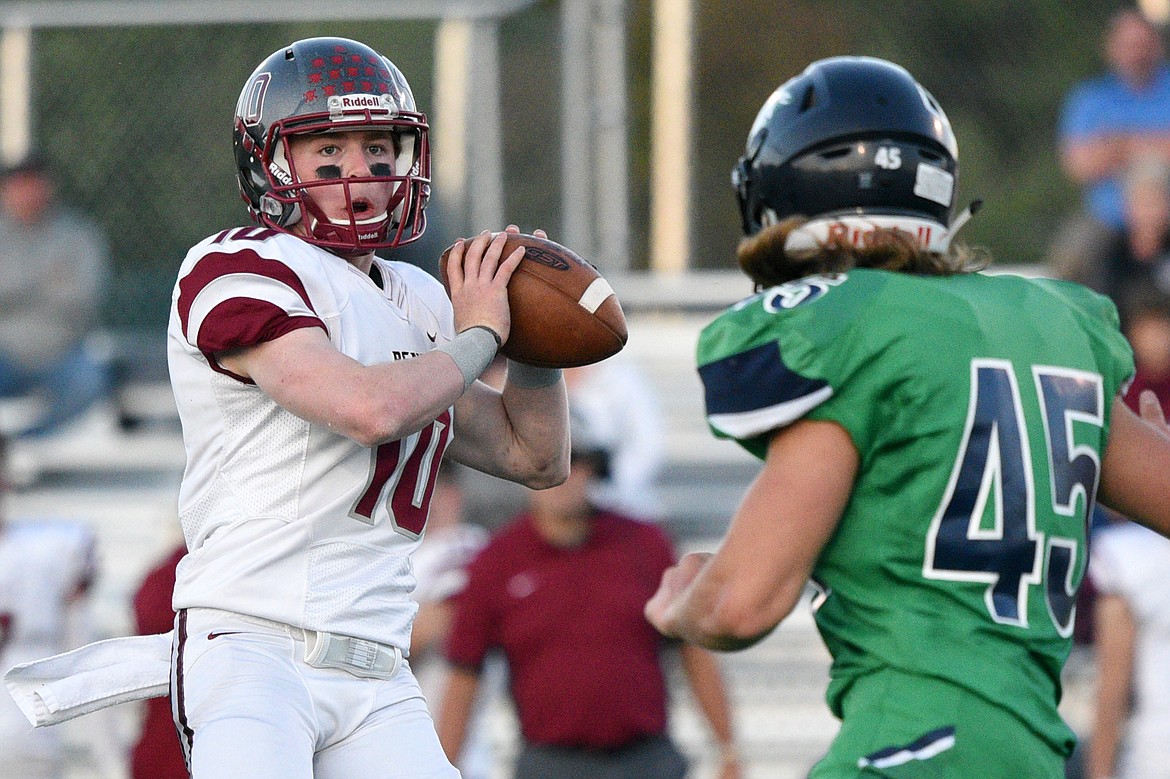 Helena quarterback Ty McGurran looks to throw under pressure from Glacier&#146;s Ethan Baines in the second quarter at Legends Stadium on Friday. (Casey Kreider/Daily Inter Lake)