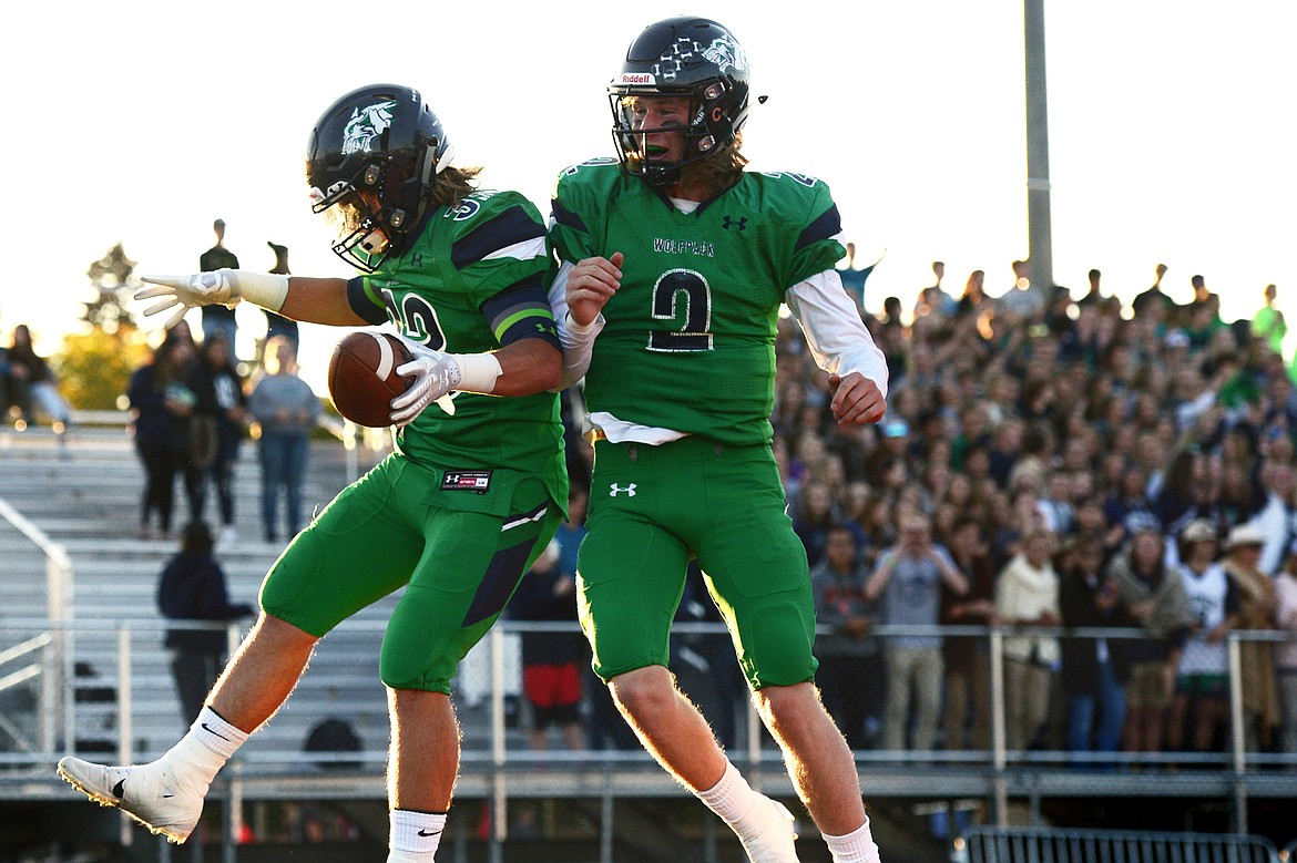 Glacier running back Preston Blain (33) celebrates with quarterback Evan Todd (2) after Blain ran in a two-point conversion after the Wolfpack&#146;s first touchdown against Helena at Legends Stadium on Friday. (Casey Kreider/Daily Inter Lake)