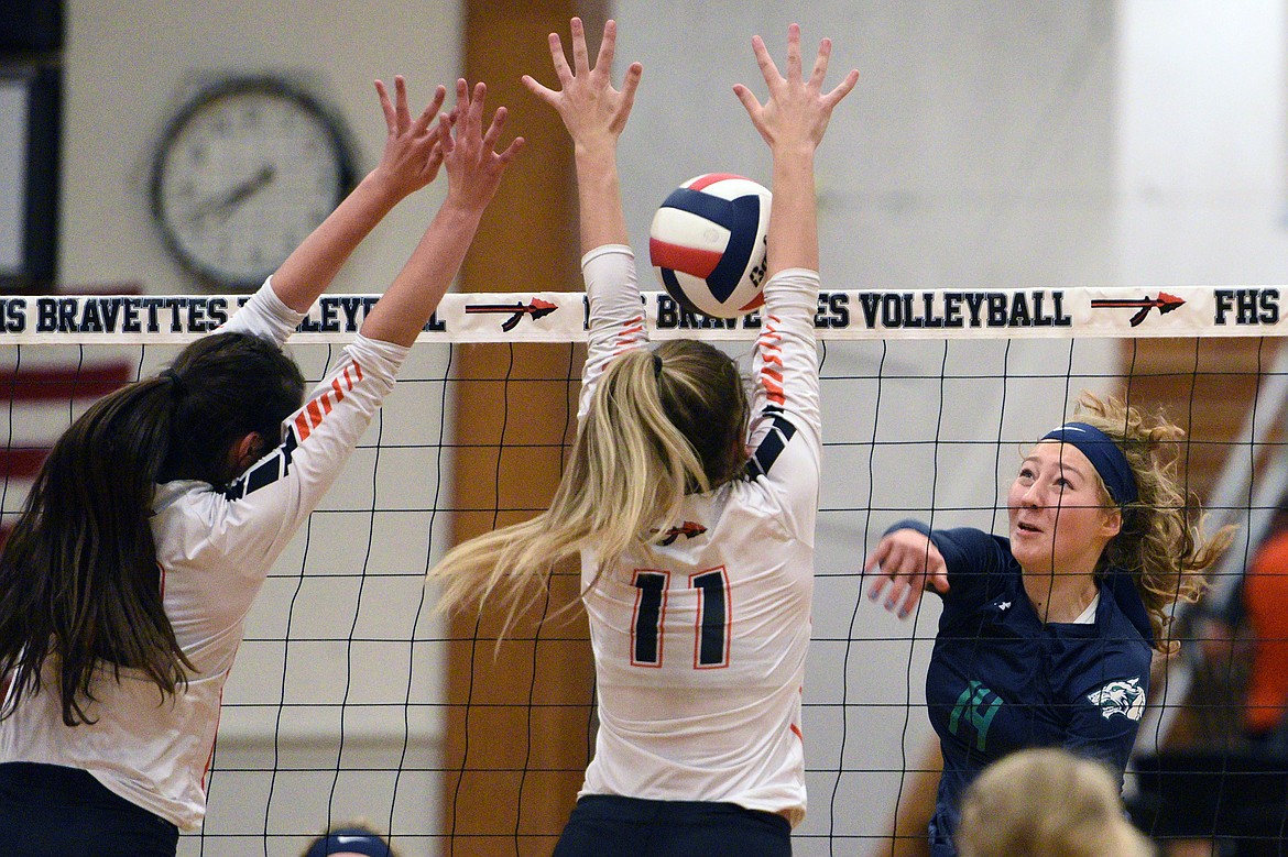 Glacier&#146;s Emma Anderson (14) goes up for a kill against Flathead&#146;s Maddie Boles (18, left) and Hannah O&#146;Dell (11) during crosstown volleyball at Flathead High School on Thursday. (Casey Kreider/Daily Inter Lake)