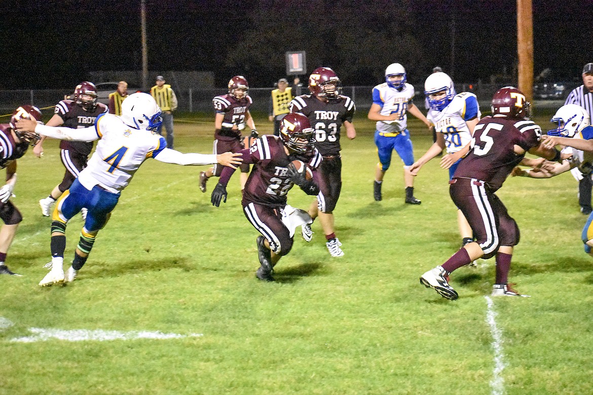 Troy senior Cy Winslow evades the Victor defenders -- as senior Tyler Gromley clears a path -- on his way to the final touchdown of the Trojans&#146; 52-25 loss to the Victor Pirates Thursday. (Ben Kibbey/The Western News)