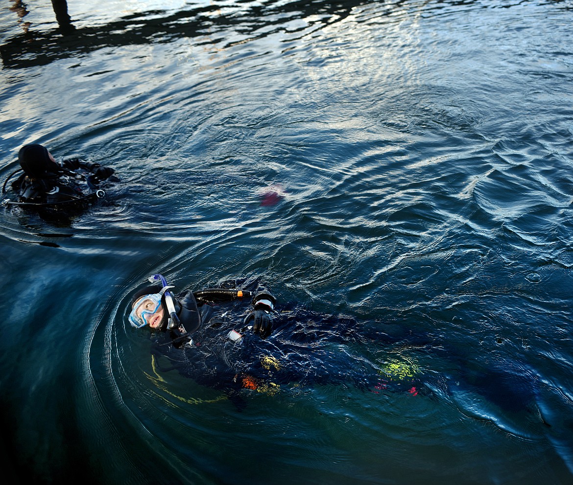 Divers make their way along the Somers Bay toward boats docked at the Somers Yacht Club on Thursday, September 13. The divers are taking part in a rapid response training to prepare them to deal with the potential discover of invasive aquatic species. While there are currently no invasive mussels in Flathead Lake, the potential does exist and must be prepared for.(Brenda Ahearn/Daily Inter Lake)