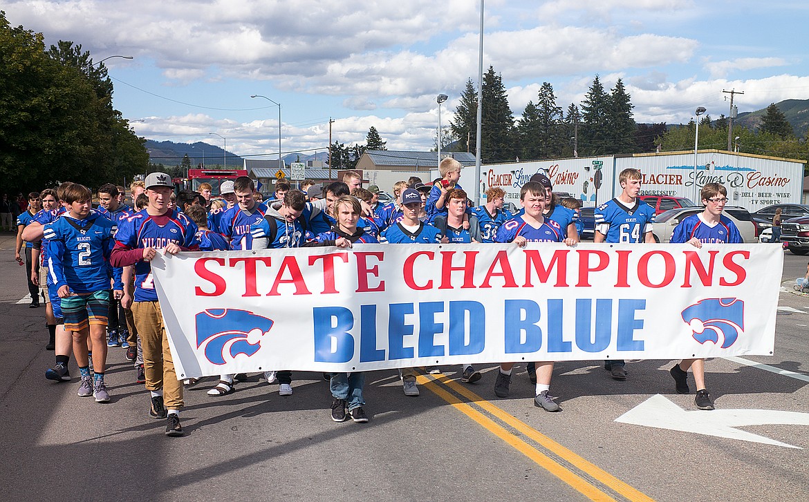 The football team walks in the parade.