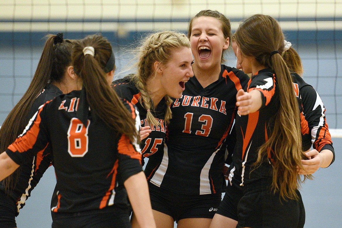 Eureka&#146;s Maggie Graves (15) and Reena Truman (13) celebrate with teammates after a point against Stillwater Christian at Stillwater Christian School on Tuesday. (Casey Kreider/Daily Inter Lake)