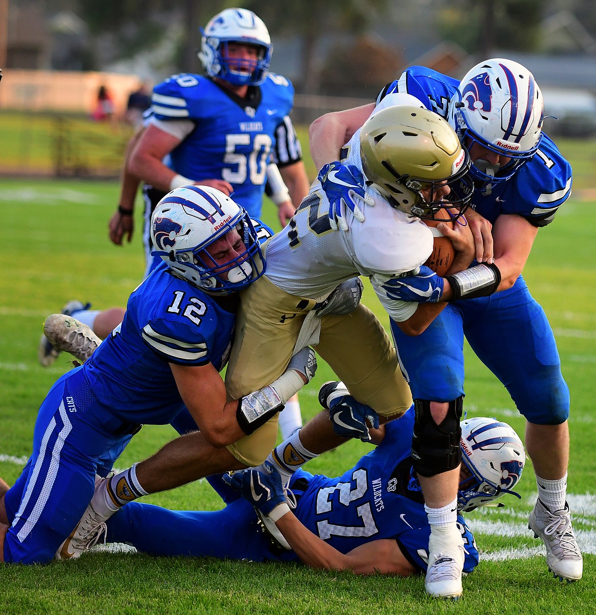 Wildcat defenders Parker Greene (12), Jason Dobson (27) and Colten McPhee take down Dillon quarterback Justus Peterson Friday. (Jeremy Weber photo)