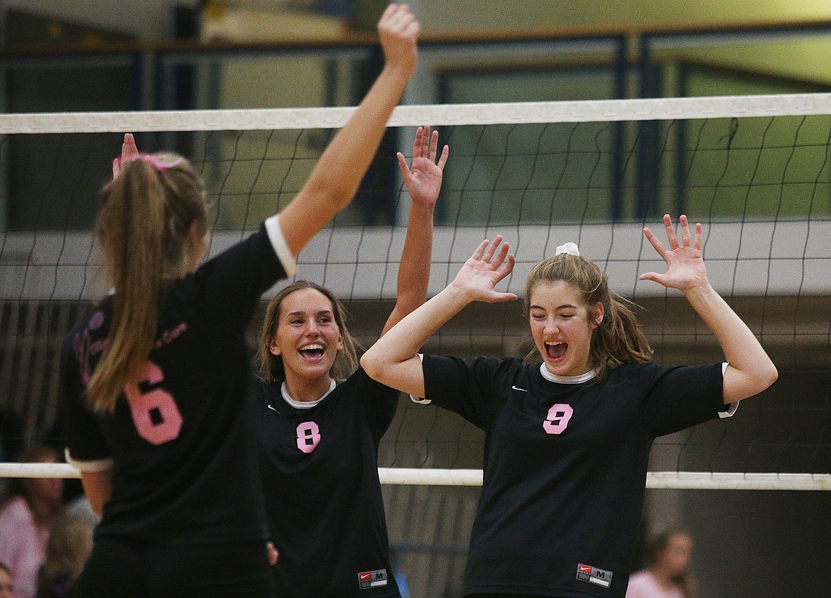Post Falls High School volleyball players Rylee Hartwig (9), Tessa Sarff (8) and Maya Blake (6) celebrate a point against Coeur d&#146;Alene Thursday in the Volleyball for the Cure match at Coeur d&#146;Alene High School. (LOREN BENOIT/Press)
