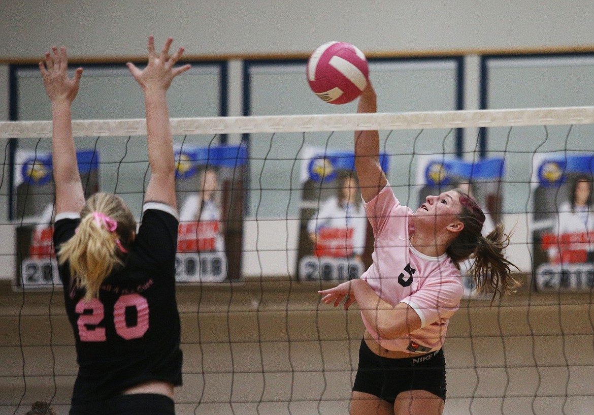 Coeur d&#146;Alene&#146;s Sarah Wilkey, right, goes for a spike as Kayla Mayo of Post Falls High goes for the block in Thurrsday&#146;s Volleyball 4 the Cure 2018 at Coeur d&#146;Alene High School. (LOREN BENOIT/Press)