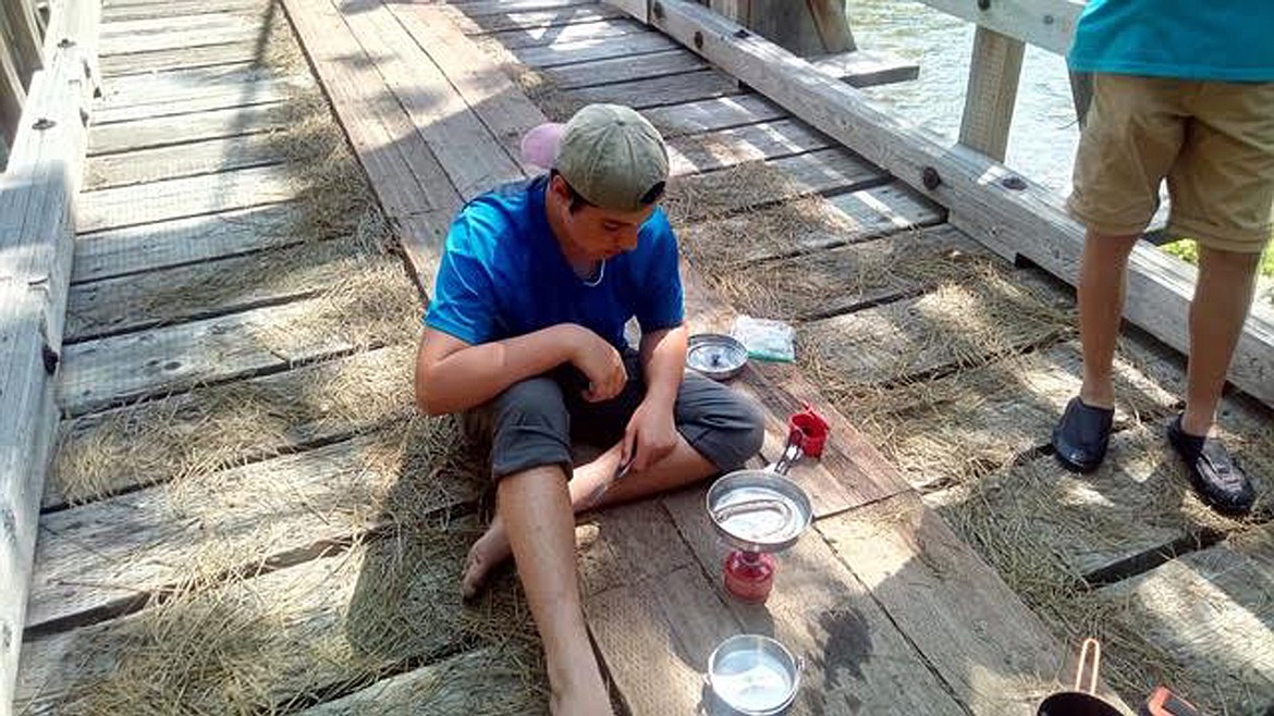 (Courtesy photo)
Daniel Magleby of Troop 111 tries frying a rattlesnake during a recent hike down the Selway River.