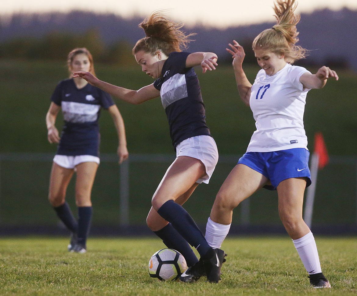 Lake City's Maddy Lasher and Coeur d'Alene's Tate Hochberger, right, battle for the soccer ball at midfield during Tuesday's match at Lake City. (LOREN BENOIT/Press)