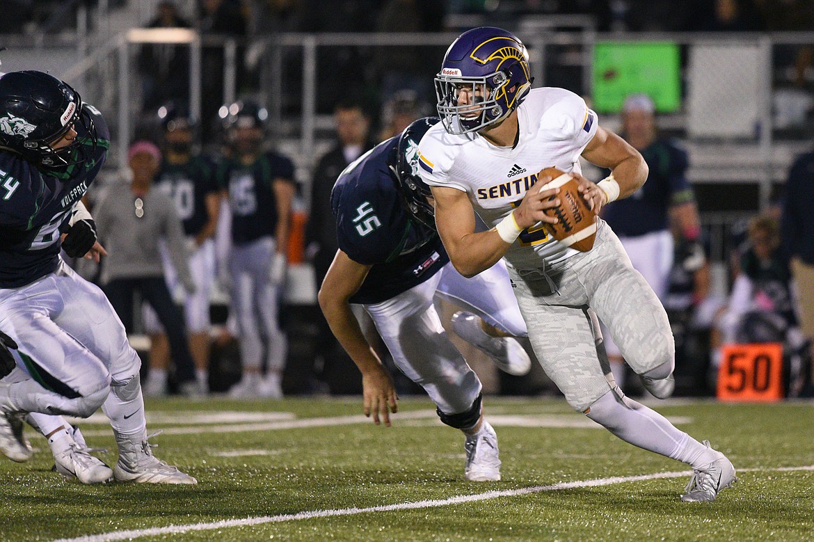 Missoula Sentinel quarterback Rylan Ortt (2) escapes pressure from Glacier's Jon deHoop (64) and Ethan Baines (45) in the first half at Legends Stadium on Friday. (Casey Kreider/Daily Inter Lake)