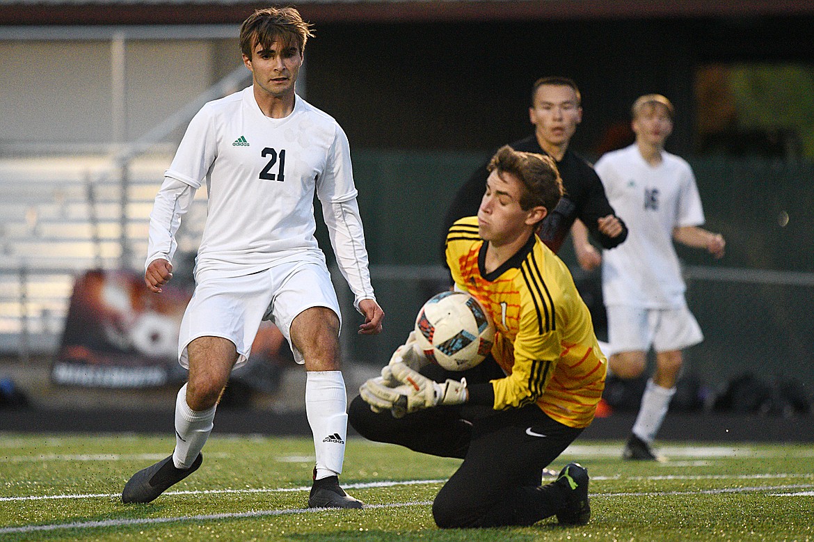 Flathead goalkeeper Max Warnell (1) scoops up a save in front of Glacier's Connor Griffin (21) during the second half of a crosstown matchup at Legends Stadium on Thursday. (Casey Kreider/Daily Inter Lake)