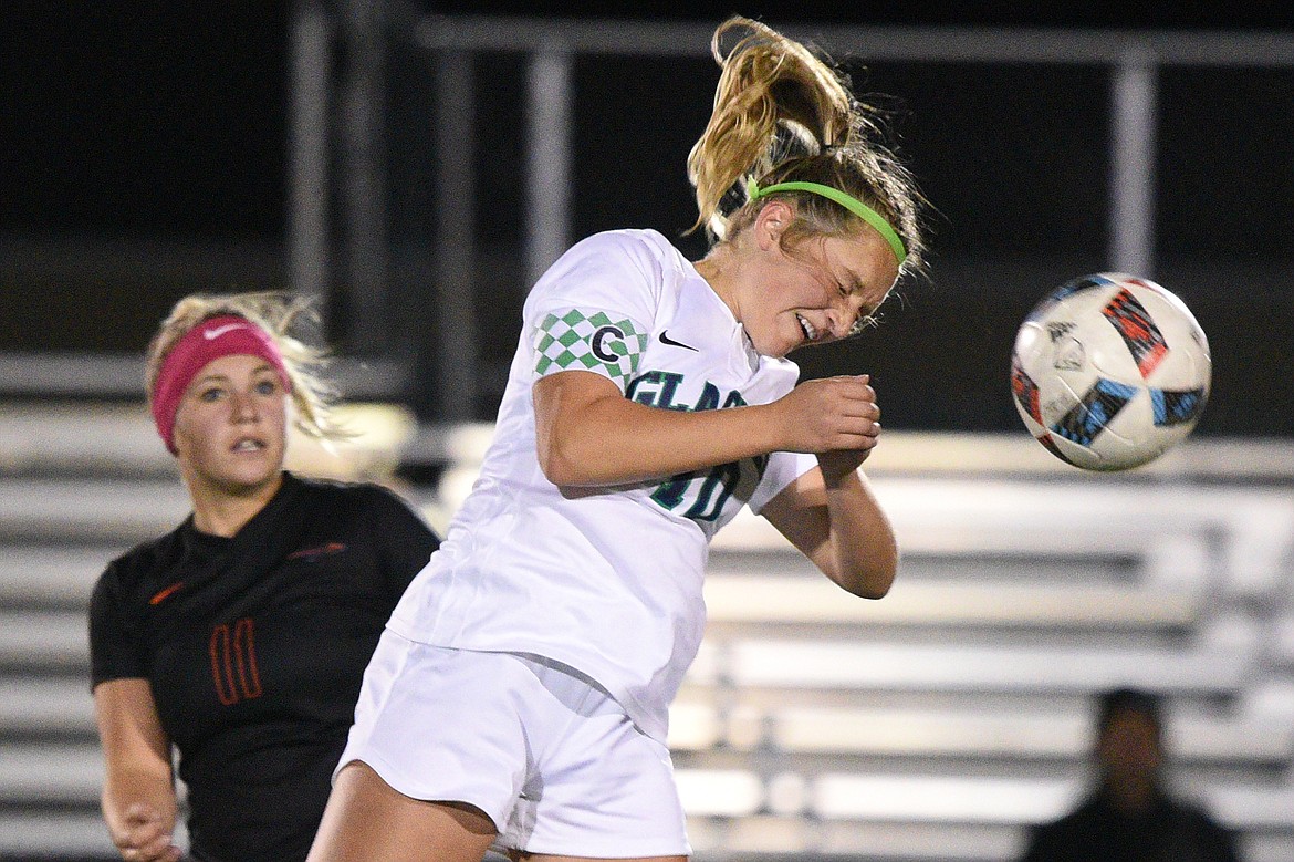 Glacier's Micah Hickethier (10) heads the ball upfield in front of Flathead's Chloe Nadeau (11) during a crosstown matchup at Legends Stadium on Thursday. (Casey Kreider/Daily Inter Lake)