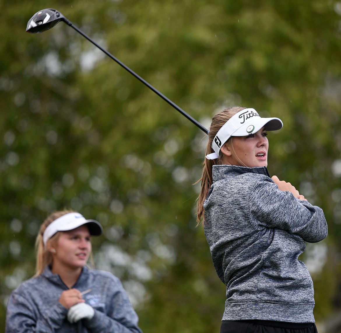 Glacier's Kate Trunkle, right, and teammate Hailey Iverson watch Trunkle's tee shot on the first hole during the Crosstown Cup at Village Greens Golf Club on Thursday. (Casey Kreider/Daily Inter Lake)