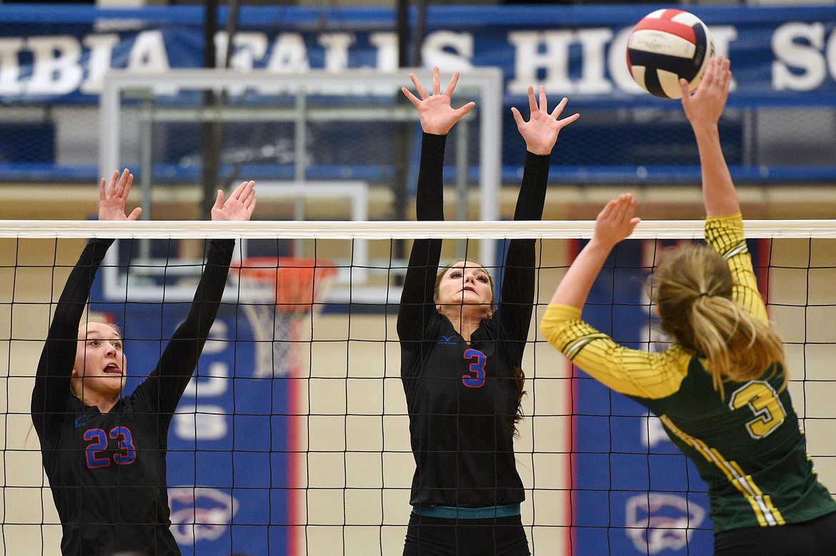 Columbia Falls' Ryley Kehr (23) and Stella Bistodeau (3) look to block a spike by Whitefish's Kennedy Grove (3) at Columbia Falls High School on Tuesday. (Casey Kreider/Daily Inter Lake)