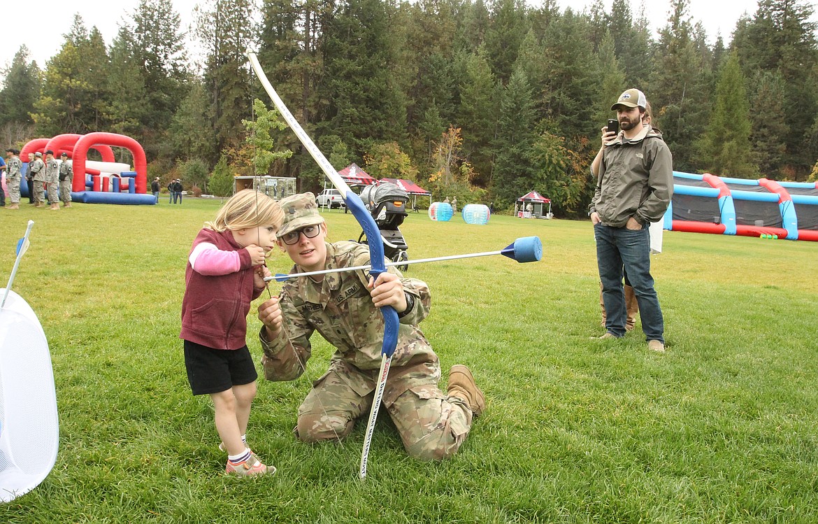 Army Cadet Maille Mathieu loads a bow for a very curious Sadi Lewis, 2, of Hayden, during the Idaho National Guard Warrior Challenge in McEuen Park on Saturday. The day consisted of National Guard training as well as activities for civilians and opportunities to meet National Guard members and learn more about their work. 

Photos: DEVIN WEEKS/Press