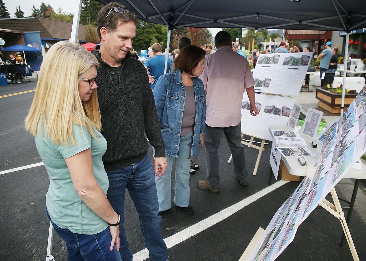 Eighth Street residents Todd and Nancy Butler look at a future East Sherman illustrations board during the fourth annual PARK(ing) it on Sherman Avenue on Friday. (LOREN BENOIT/Press)
