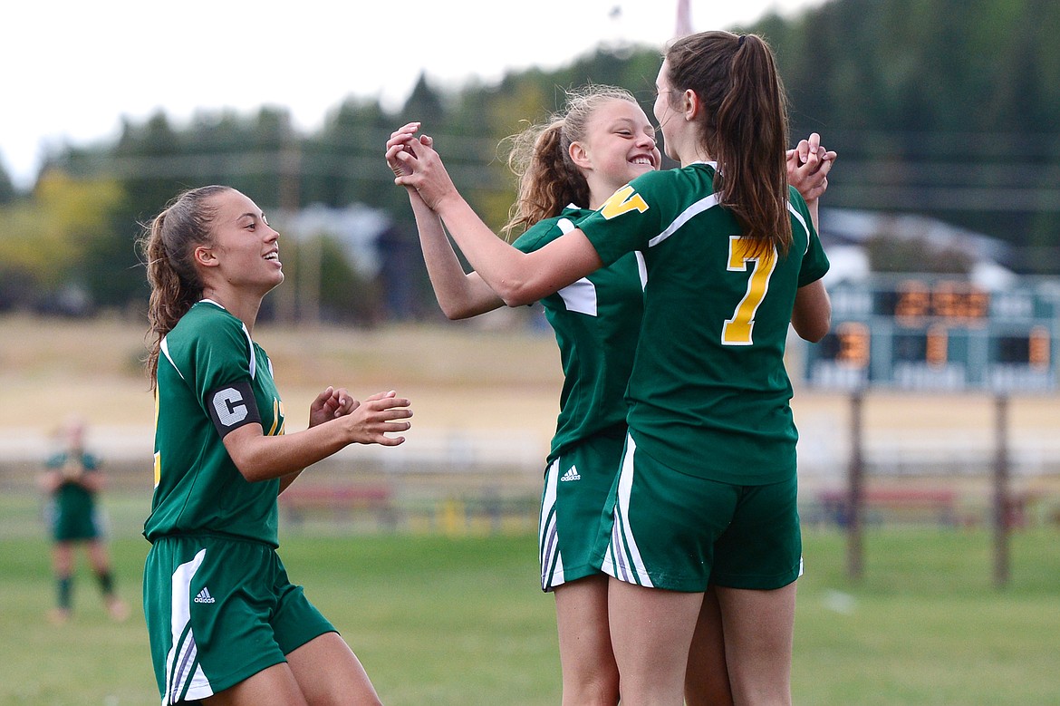 Whitefish's Anna Cook, left, Taylor Gentry, center, and Olivia Potthoff celebrate Gentry's goal in the first half against Polson at Smith Fields in Whitefish on Saturday. (Casey Kreider/Daily Inter Lake)