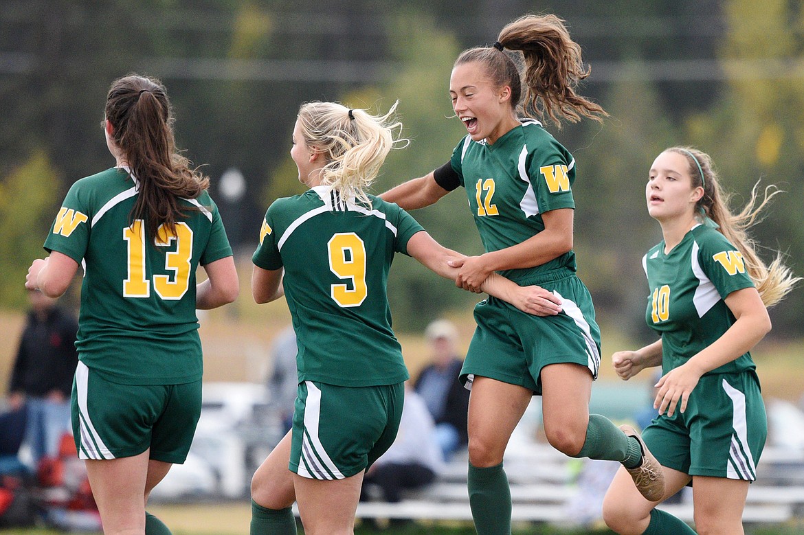 Whitefish's Thea Vrentas (13), Saylor Schlauch (9), Anna Cook (12) and Ali Hirsch celebrate after Schlauch's goal against Polson at Smith Fields in Whitefish on Saturday. (Casey Kreider/Daily Inter Lake)