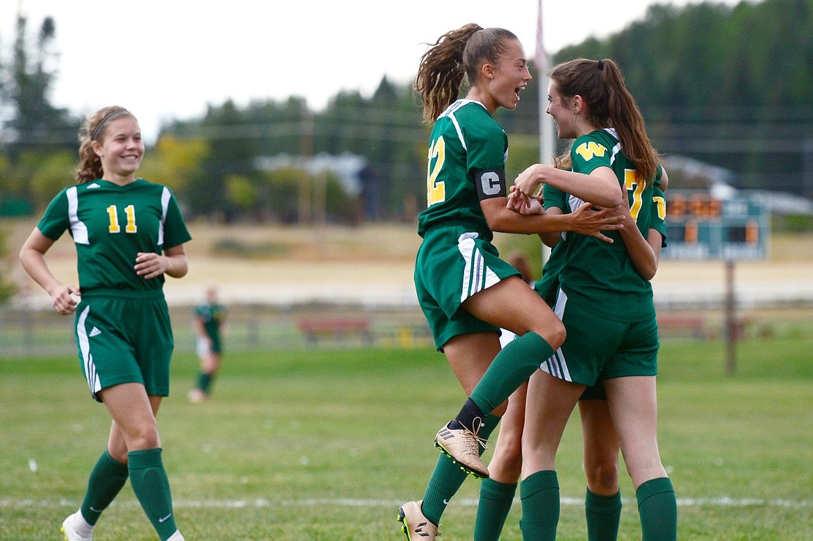 Whitefish's Emma Barron (11), Anna Cook (12) Taylor Gentry (6) and Olivia Potthoff (7) celebrate Gentry's goal in the first half against Polson at Smith Fields in Whitefish on Saturday. (Casey Kreider/Daily Inter Lake)