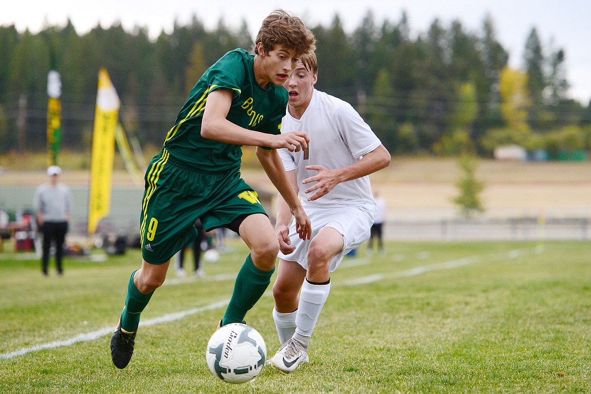 Whitefish's Gabe Menicke (9) works the ball past Polson defender Zevam Walker (7) at Smith Fields in Whitefish on Saturday. (Casey Kreider/Daily Inter Lake)