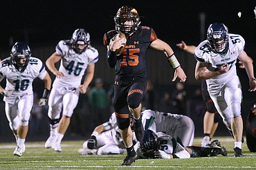 Flathead quarterback Jaden MacNeil (15) heads to the end zone on a 36-yard touchdown run in the third quarter of a crosstown matchup with Glacier at Legends Stadium on Friday. (Casey Kreider/Daily Inter Lake)