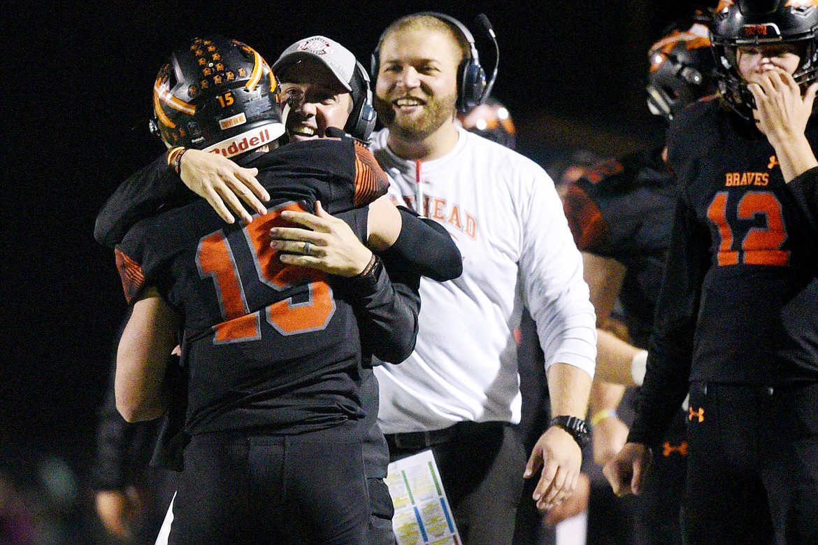 Flathead head coach Kyle Samson congratulates quarterback Jaden MacNeil (15) after MacNeil's 36-yard touchdown run in the third quarter of a crosstown matchup with Glacier at Legends Stadium on Friday. (Casey Kreider/Daily Inter Lake)