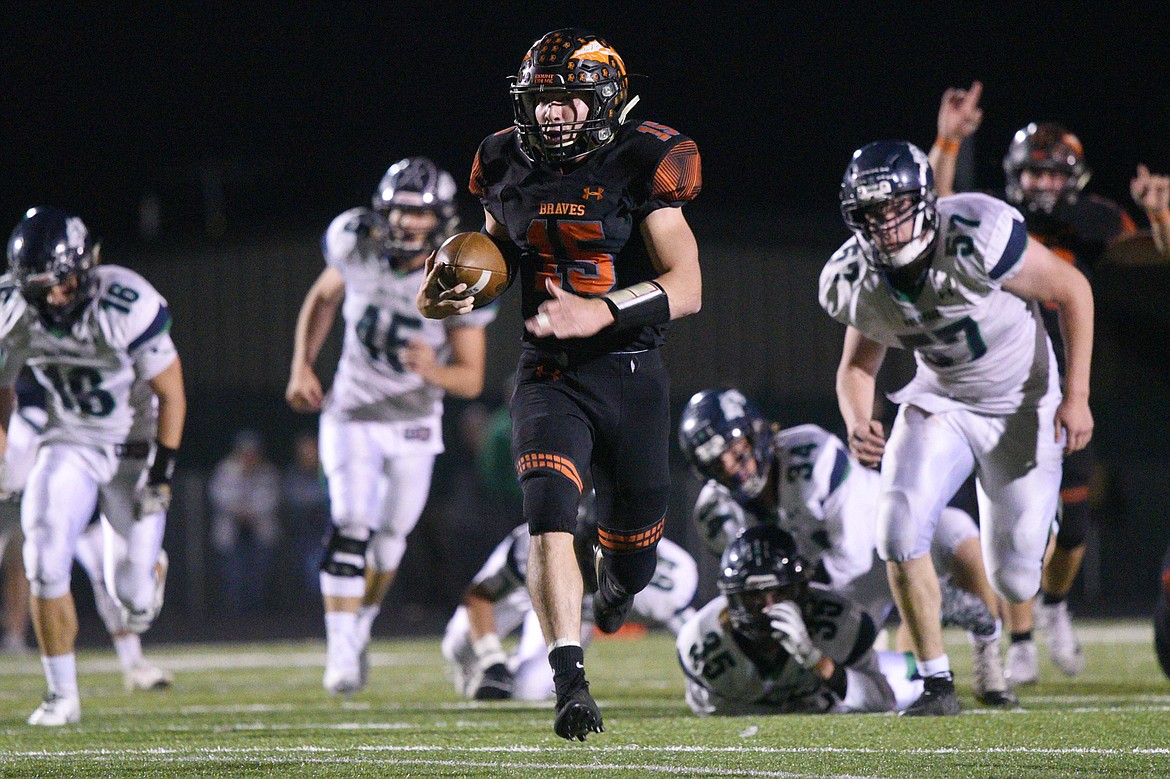 Flathead quarterback Jaden MacNeil (15) heads to the end zone on a 36-yard touchdown run in the third quarter of a crosstown matchup with Glacier at Legends Stadium on Friday. (Casey Kreider/Daily Inter Lake)