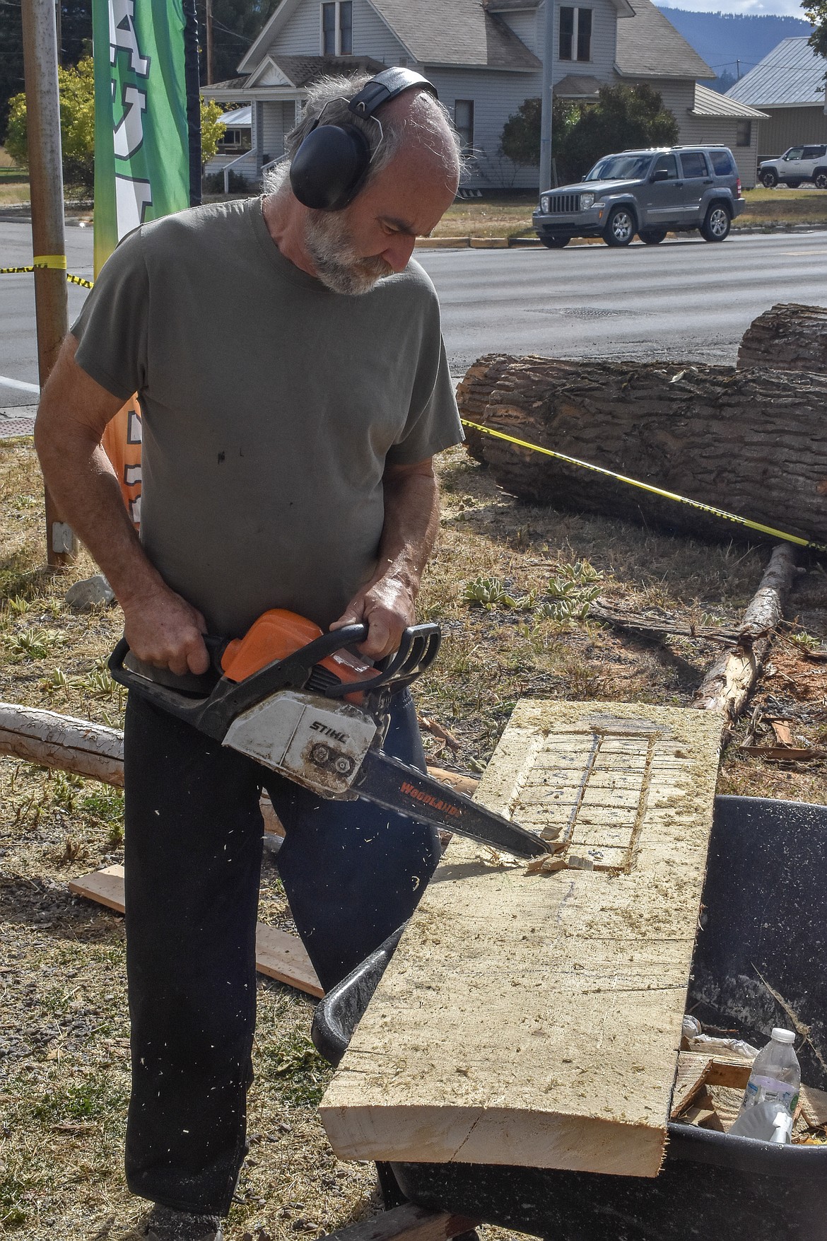 Gary Jewell, from Trego, works on one of his customary chainsaw-carved sign during the quick carve period on Sunday morning at Ron Adamson&#146;s The Libby Chainsaw Event. (Ben Kibbey/The Western News)