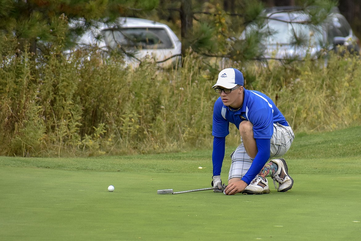 Libby freshman Landon Haddock lines up his putt on the 17th hole during the Western &#145;A&#146; Divisional at Cabinet View Golf Club in Libby Friday. (Ben Kibbey/The Western News)