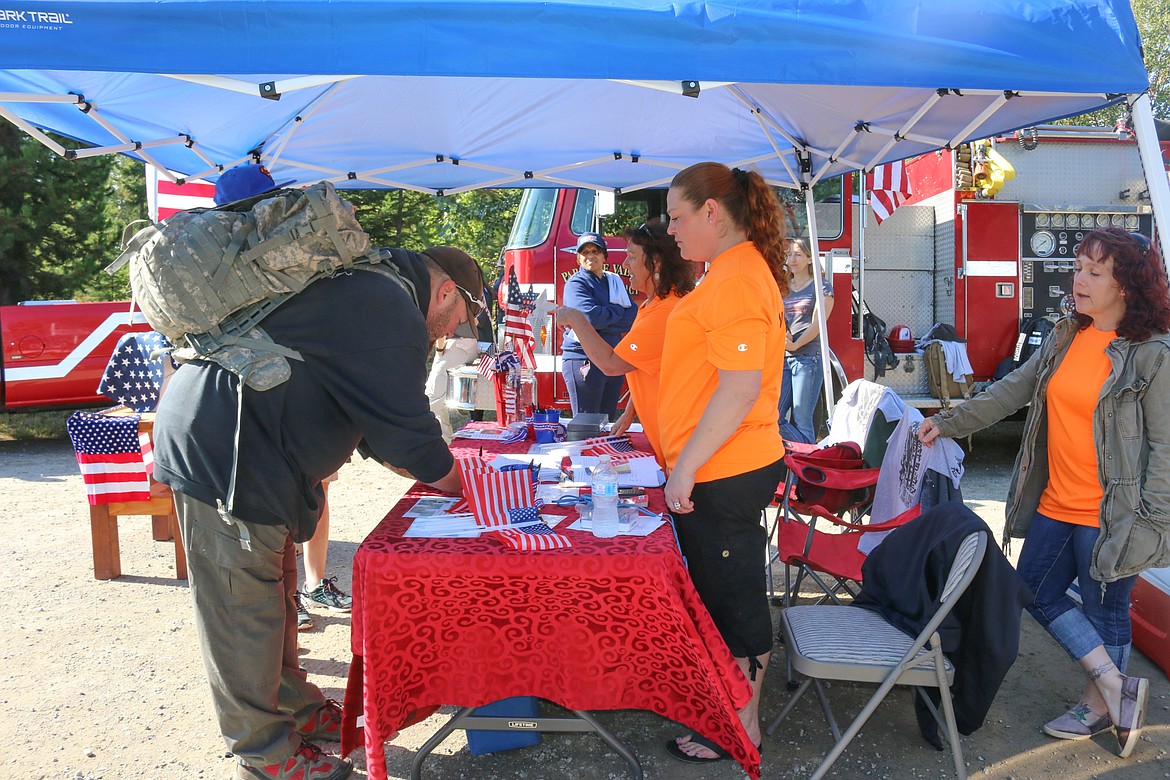 Photo by MANDI BATEMAN
Signing up for the ruck-march with volunteer Molly High.